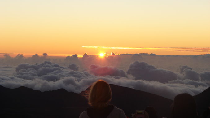 The sun rises over the clouds at Haleakala Crater, Maui