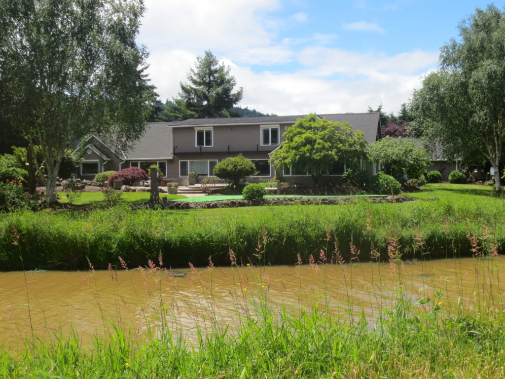 house with putting green in back yard